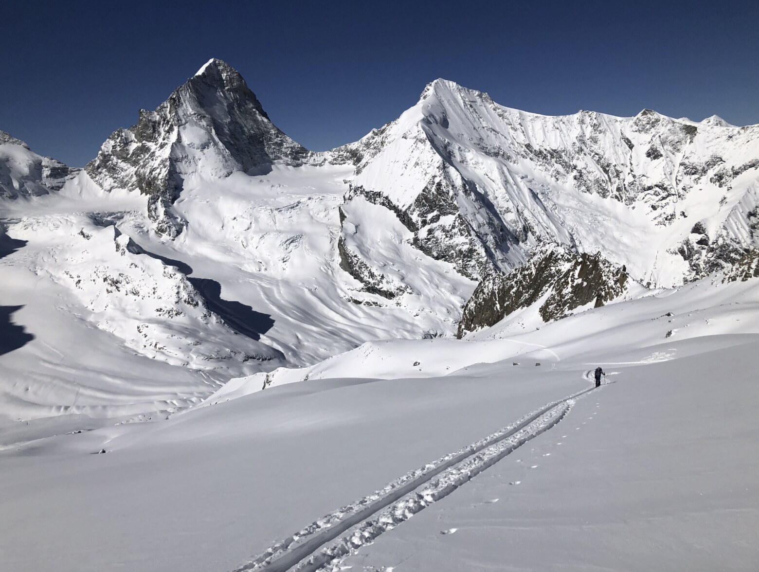 Wind-sculpted snow ridges at blue hour, sastrugi patterns across an alpine landscape